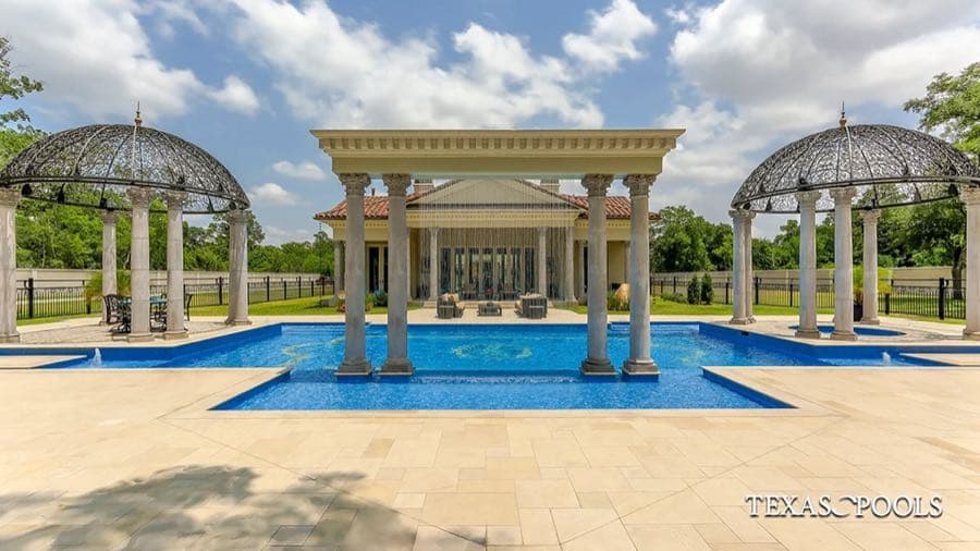 Custom pool with columned fountain and travertine deck