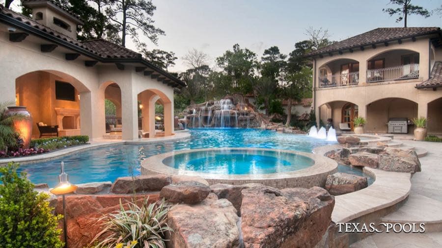 Resort-style pool with grotto waterfall and outdoor kitchen