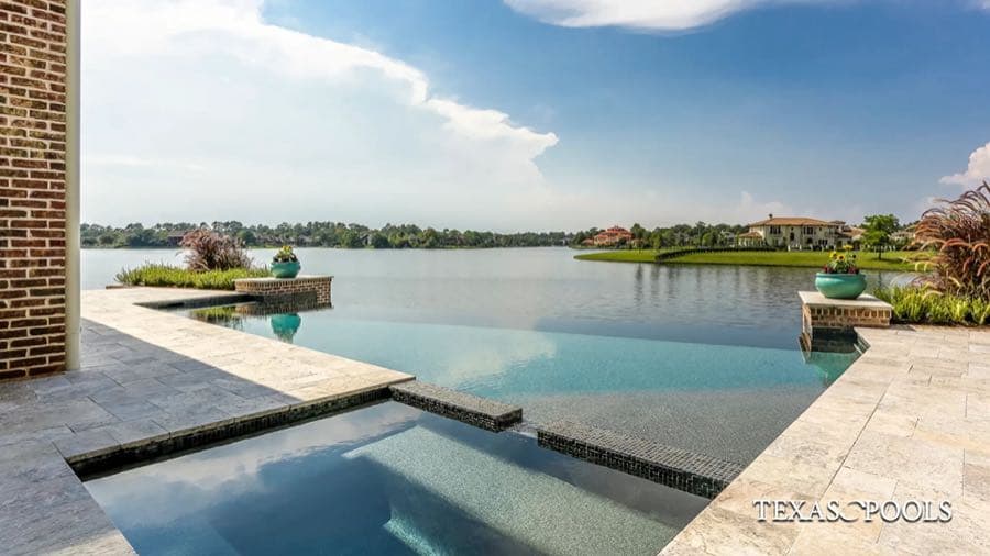Freeform pool with rock waterfall and stone patio