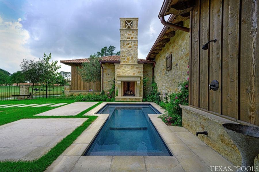 Lagoon-style pool with slide and lush landscaping