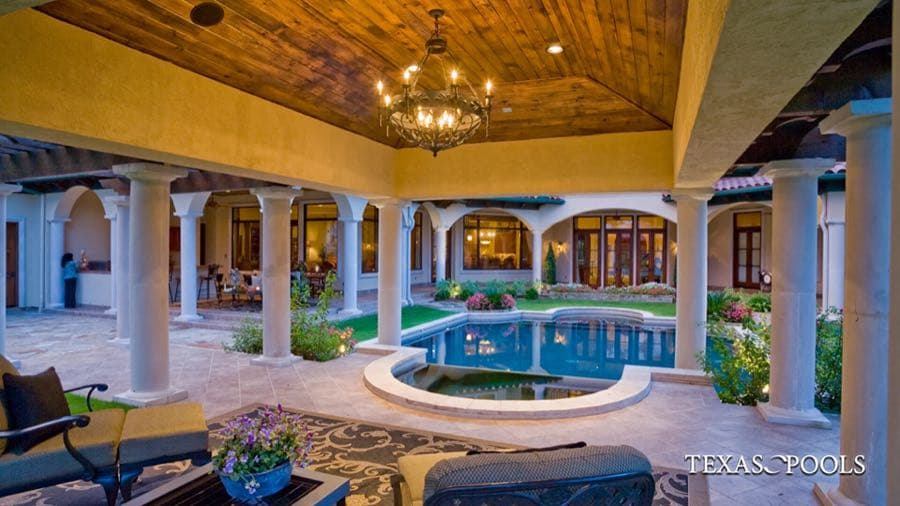 Formal pool with fountain jets and manicured lawn